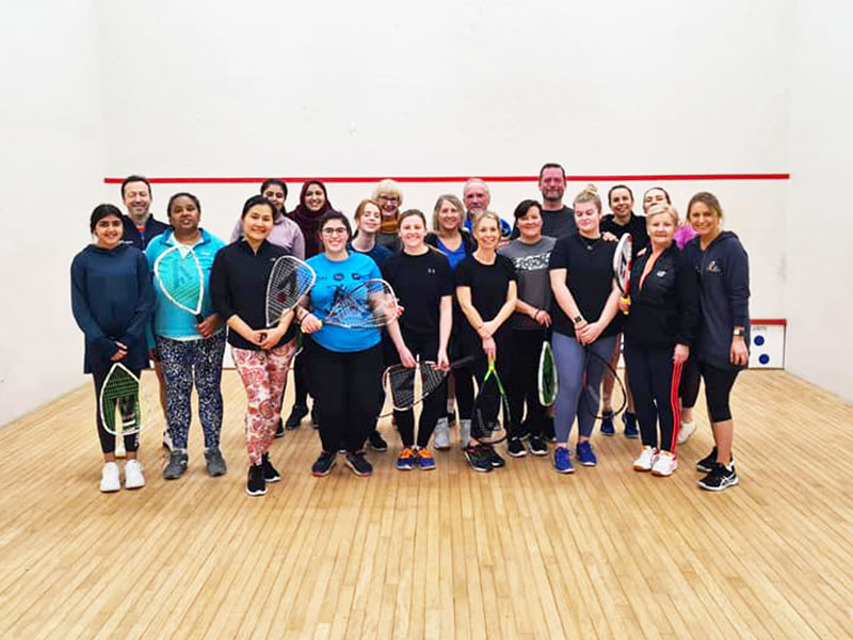 Women standing together on a squash court